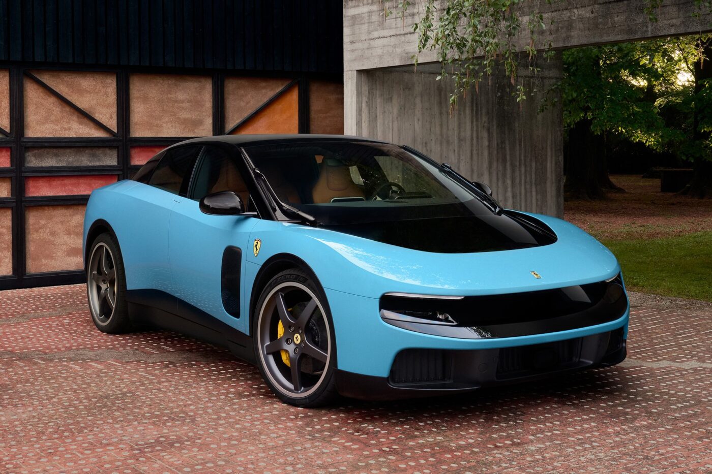 Ferrari Luce electric car in blue metallic finish with sleek design showing five-seater interior designed by Jony Ive at unveiling event Maranello Italy