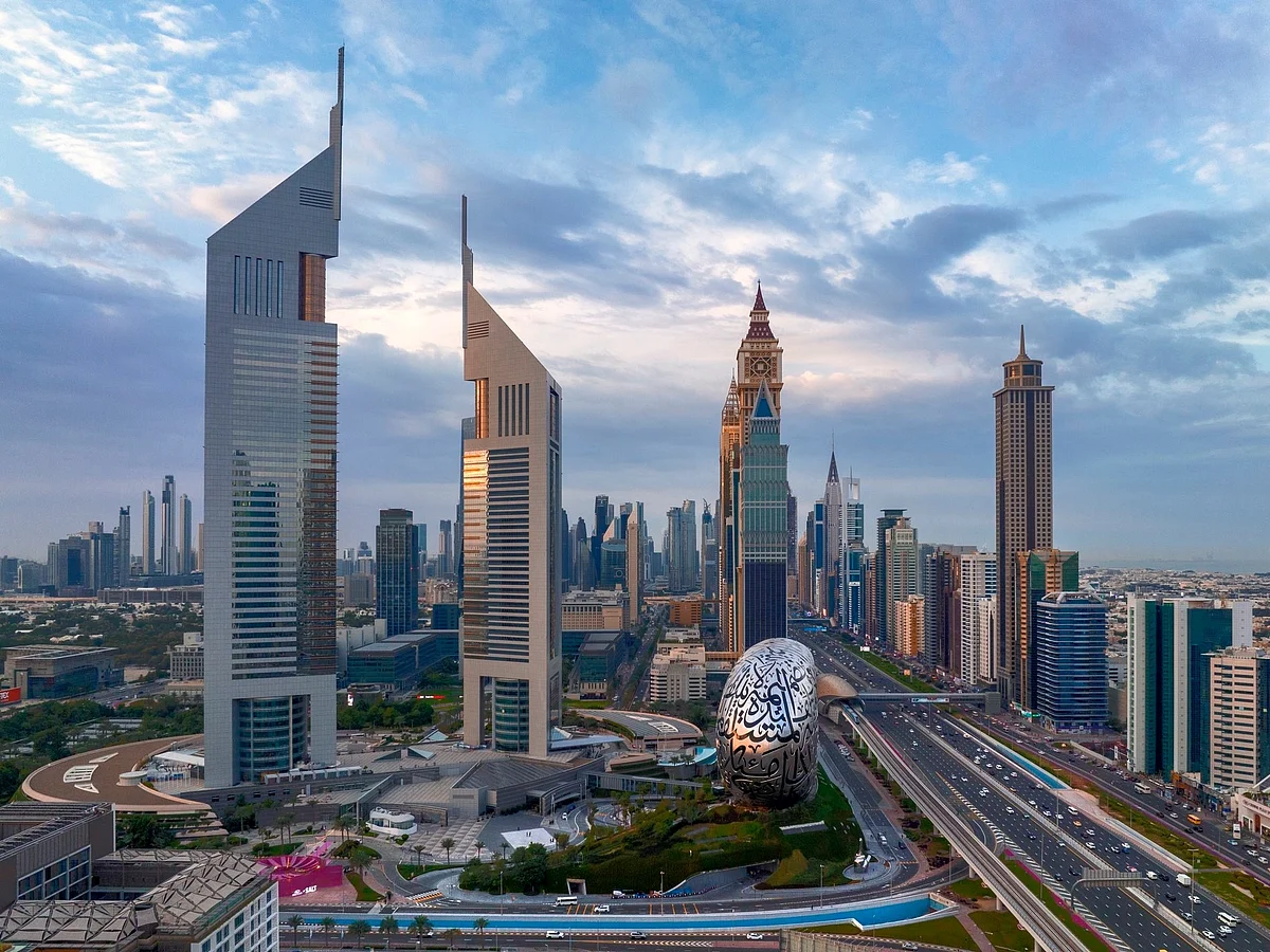 A heat haze shimmers over the modern skyline of Dubai as the sun shines through a light afternoon mist.