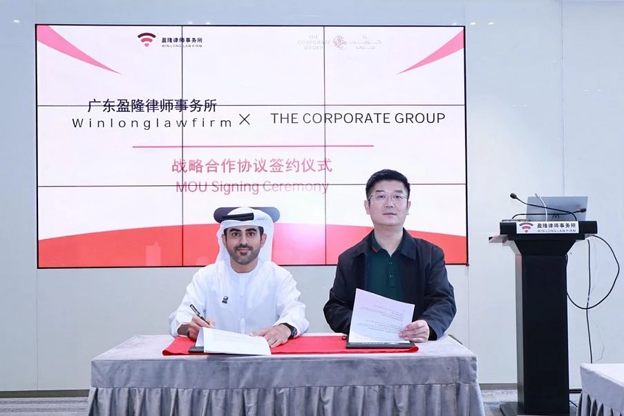 Business professionals shake hands in a modern office before the city skylines of Dubai and Beijing.
