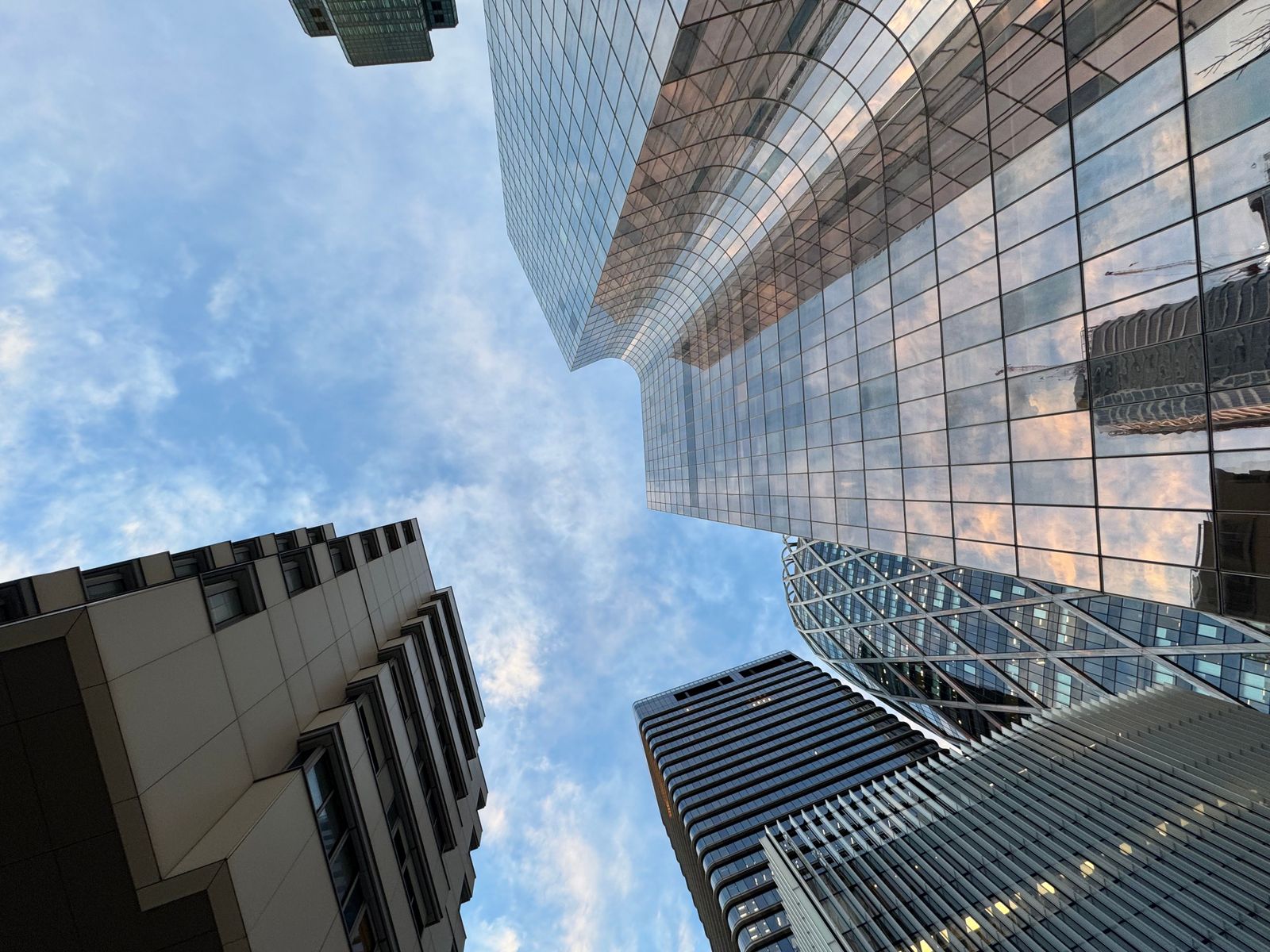 Modern glass skyscrapers of the Qatar Financial Centre reflect a clear blue sky in the heart of Doha's business district.