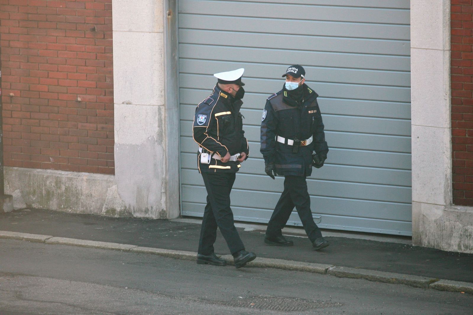 Police officers stand near a cordoned street in the Dora district after a fatal shooting during a demolition operation.