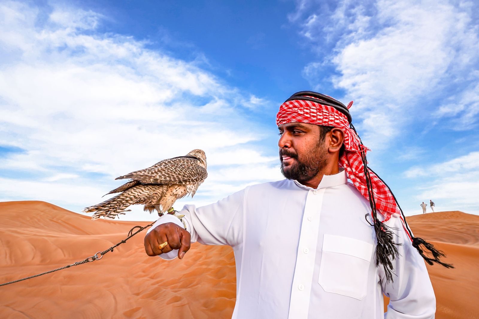 A portrait of Badr Abdullah Mohammed Al Harmi smiling against a blurred outdoor background.