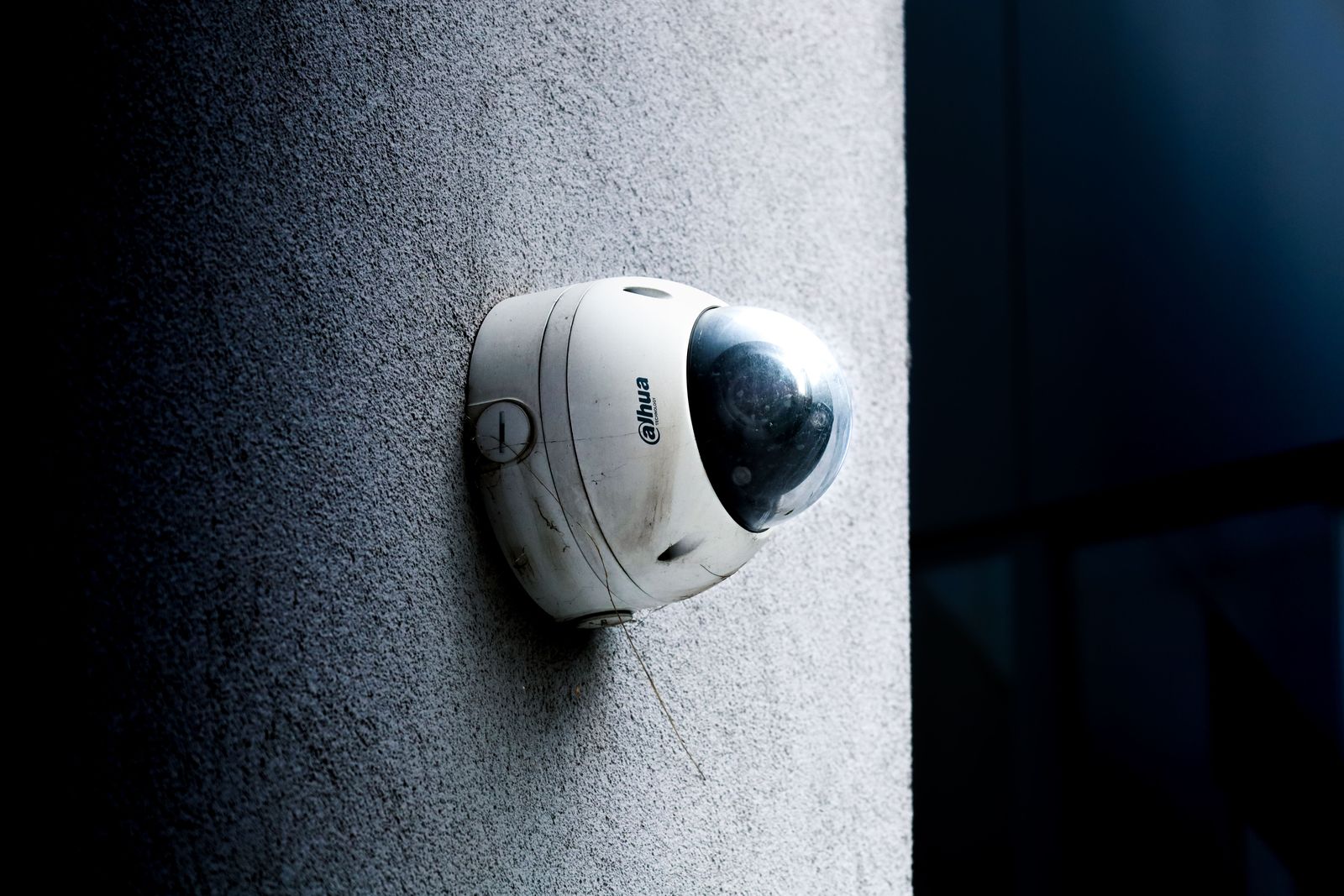 A person holds a smartphone displaying a digital facial recognition scan and glowing data security icons.