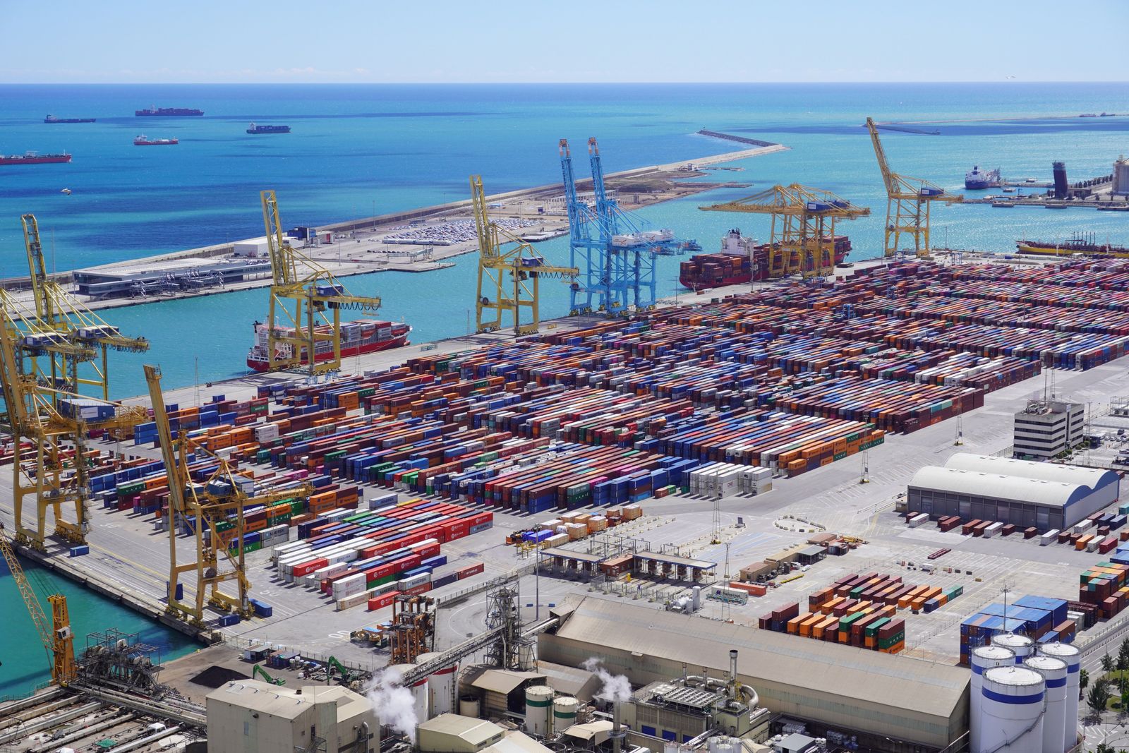 Cargo ships docked at a bustling industrial port reflect growing trade between Jordan and the United Arab Emirates.