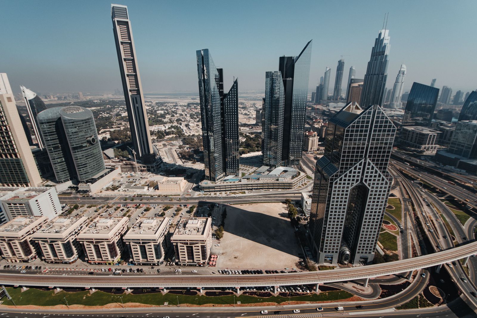 Architectural rendering shows a modern, sprawling white exhibition complex under a clear sky in the heart of Dubai.