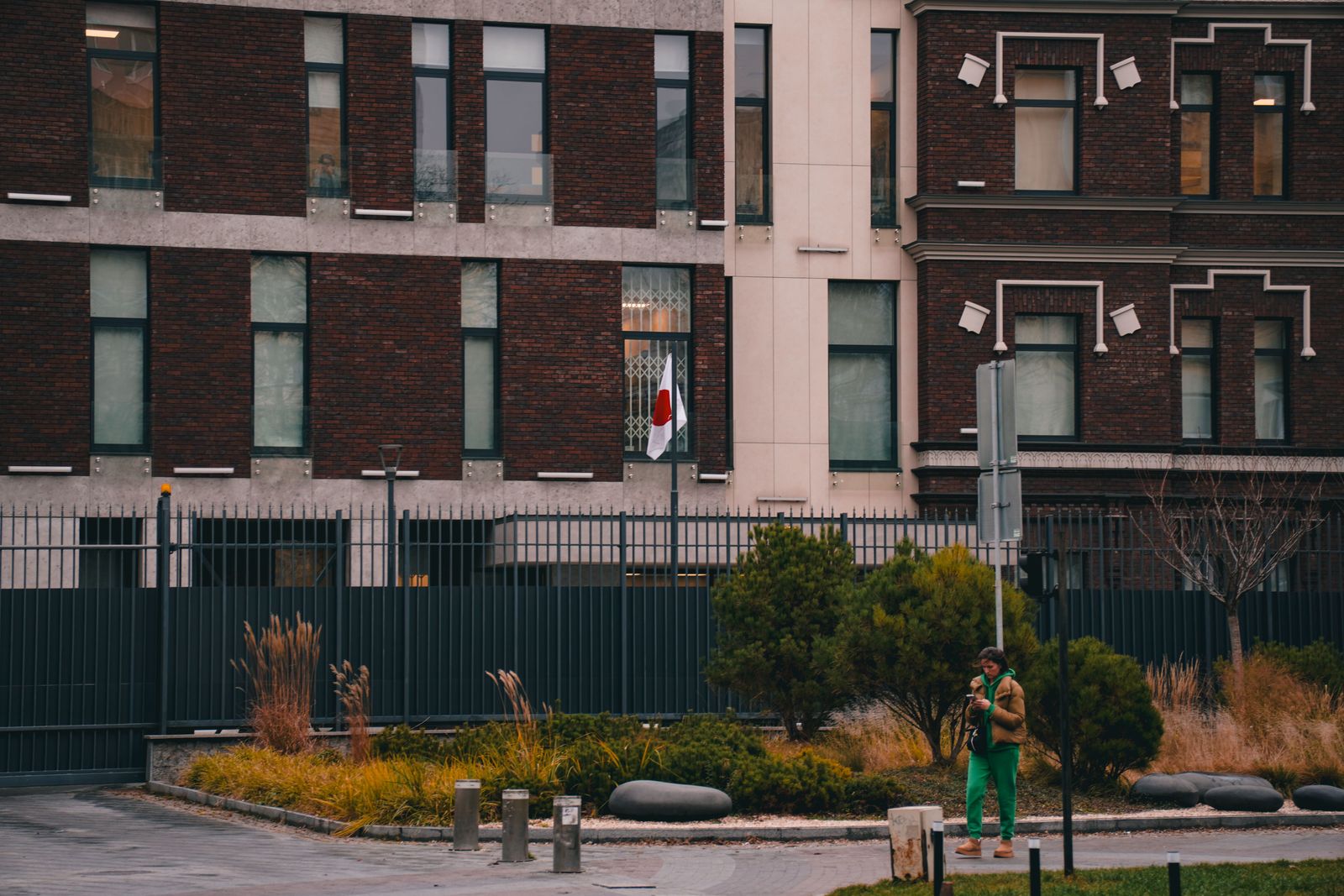 The Iranian national flag flutters against a blurred urban backdrop, symbolizing internal political tension in Tehran.