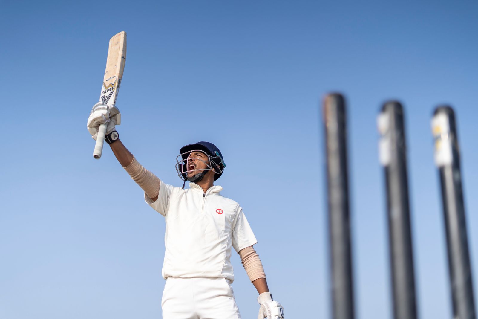 Virat Kohli follows through on a powerful cricket shot while batting in a stadium during a match against the West Indies.