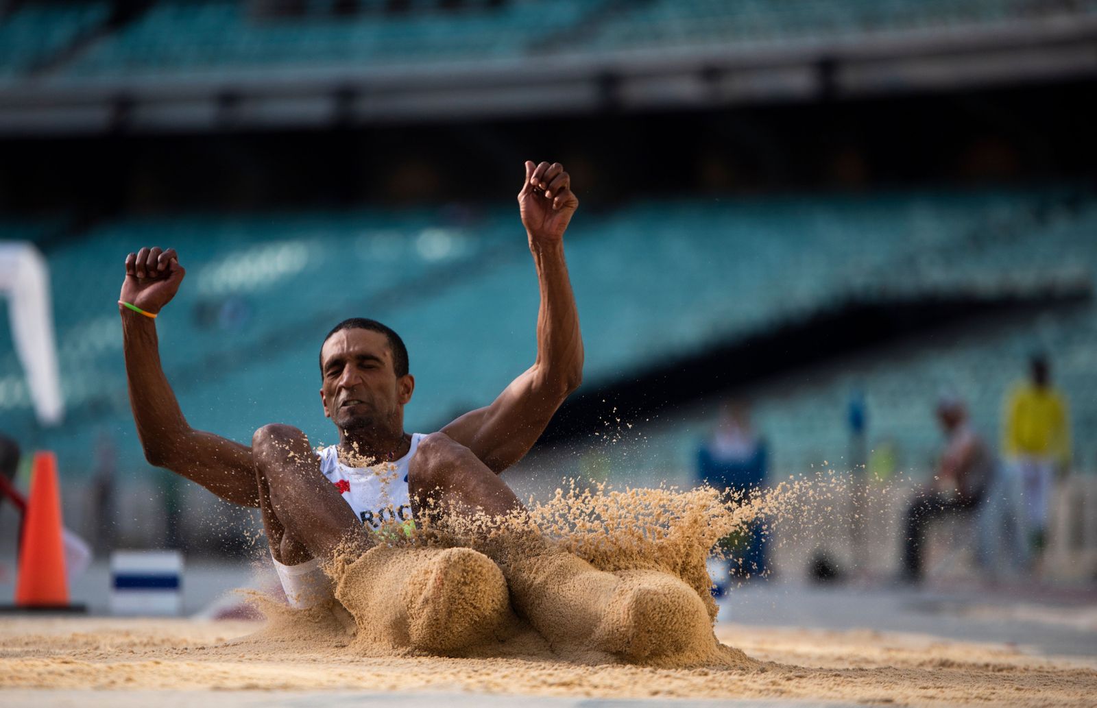 Rumesh Pathirage leans back and launches a javelin across a stadium track under bright arena lights in Nagoya.