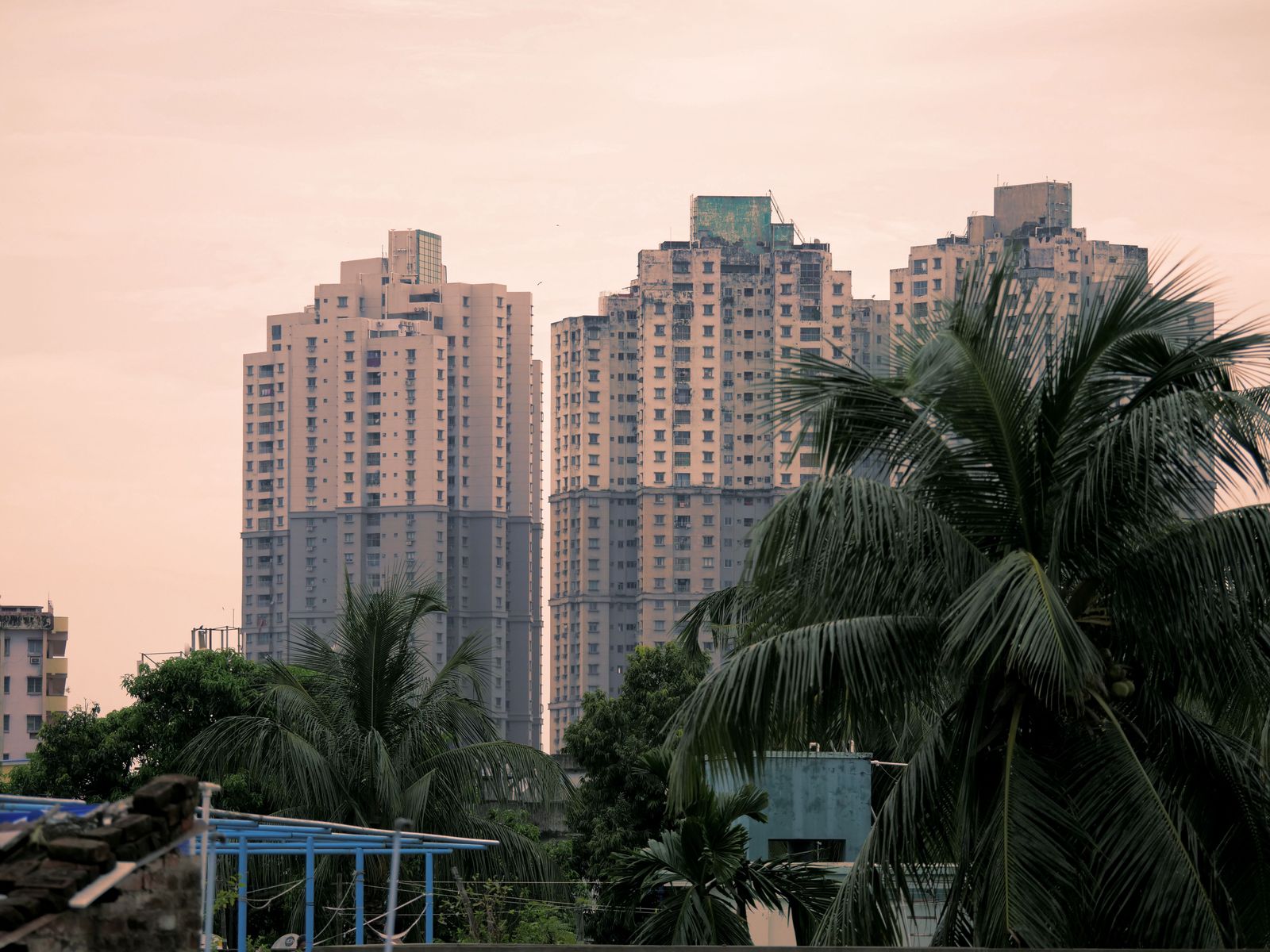 A group of young Indian professionals discusses opportunities against a blurred cityscape background of modern skyscrapers.