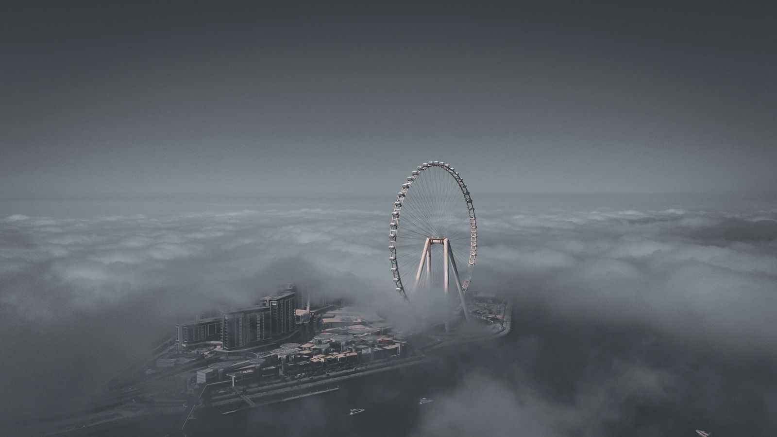 Thick white fog blankets a multilane highway in the UAE as vehicle headlights glow through the hazy morning mist.
