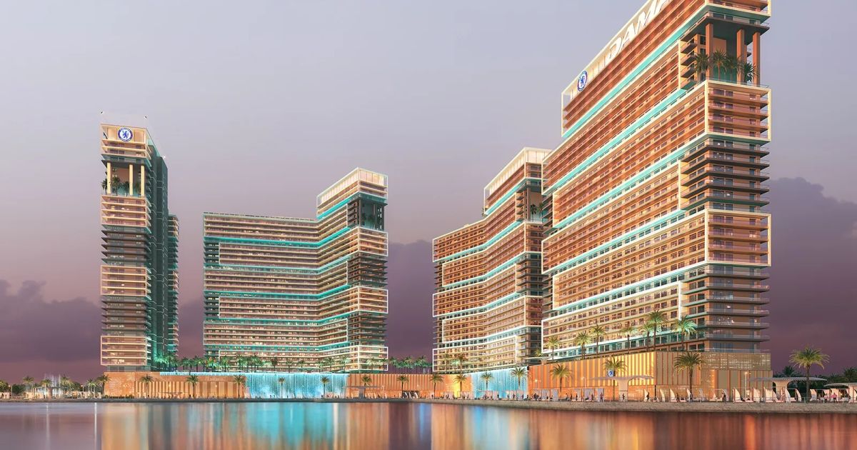 A sleek glass skyscraper overlooks a calm blue sea under a clear sky in a modern waterfront district. | credit:Publicly Available