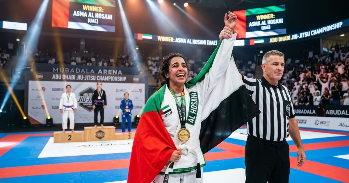 Three female UAE athletes in white gis smile and hold gold medals on a podium at the Jiu-Jitsu World Championship.