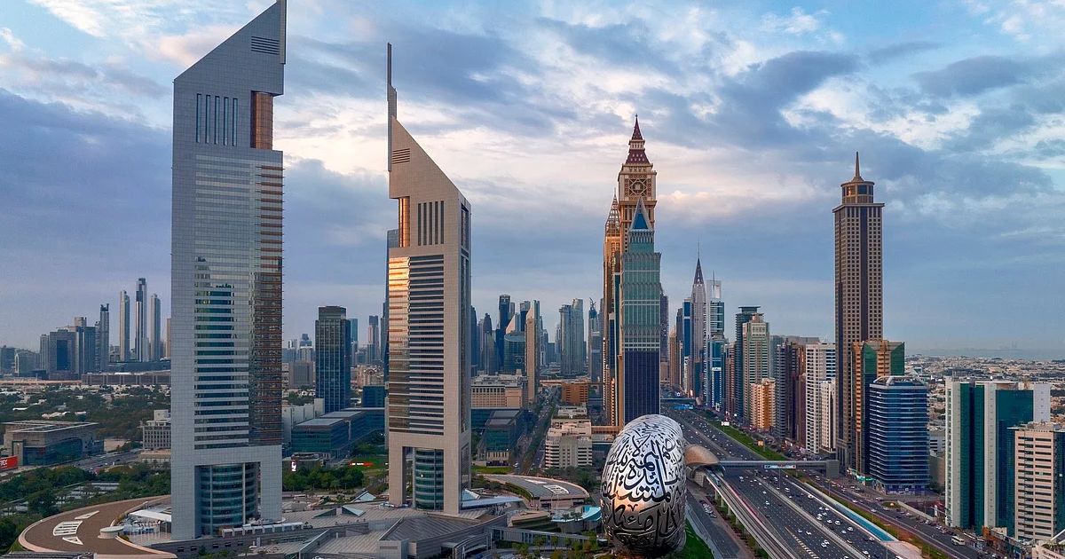 A heat haze shimmers over the modern skyline of Dubai as the sun shines through a light afternoon mist.